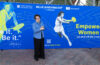 Billie Jean King standing in front of a banner that reads Billie Jean King Cup.