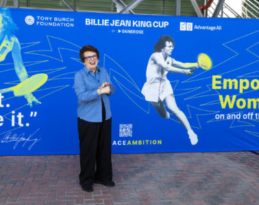 Billie Jean King standing in front of a banner that reads Billie Jean King Cup.